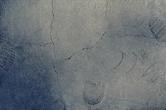 Cracked concrete surface with old boot prints set in it