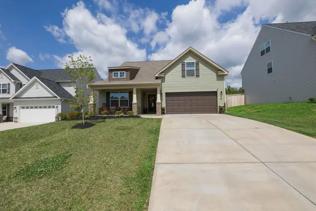 Long concrete driveway running up to a single-story house