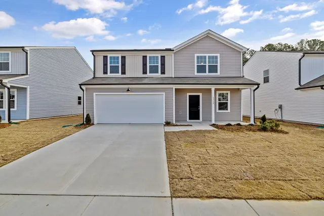 Wide new concrete driveway in front of a two-story house