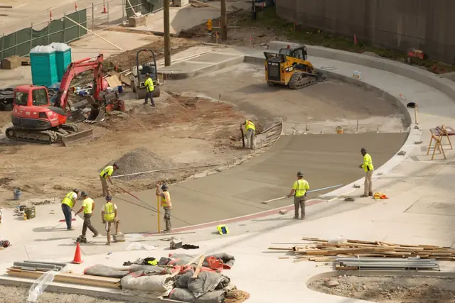 Crew placing and finishing a large concrete pour on a street job
